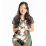 female with long dark hair holding a cat